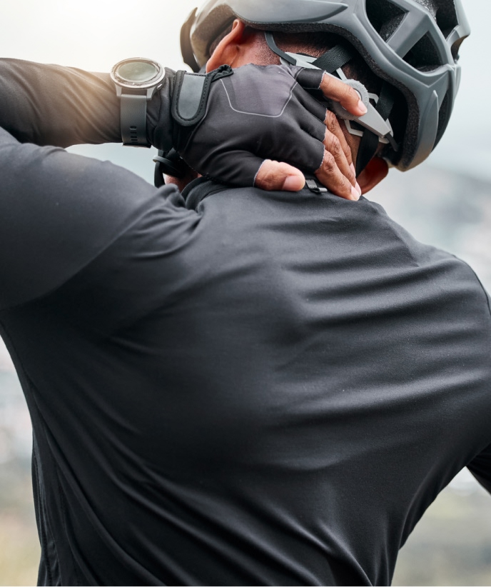 Cyclist holding his neck and back in pain, seeking neck and back pain relief